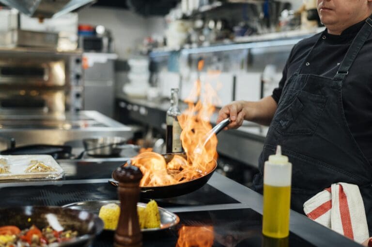 side-view-male-chef-flambeing-dish